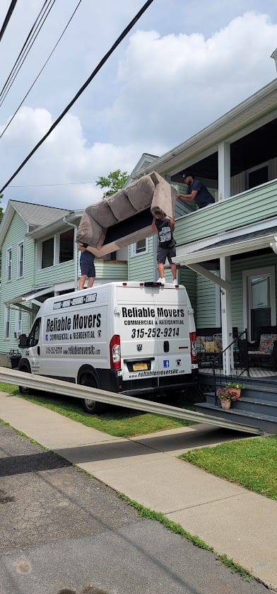 Reliable Movers crew safely lowering a couch from a second-story balcony during a residential move.