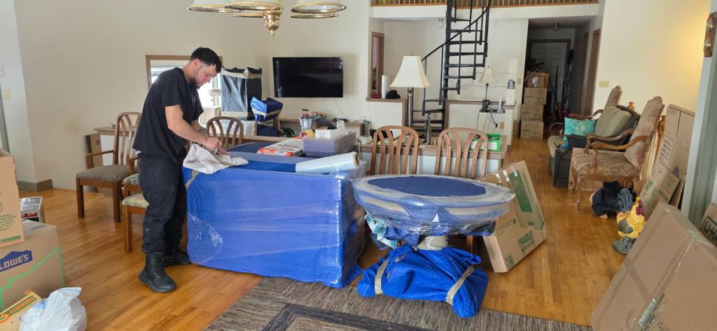 Professionally wrapped furniture prepared for a residential move, demonstrating careful packing and protection services.