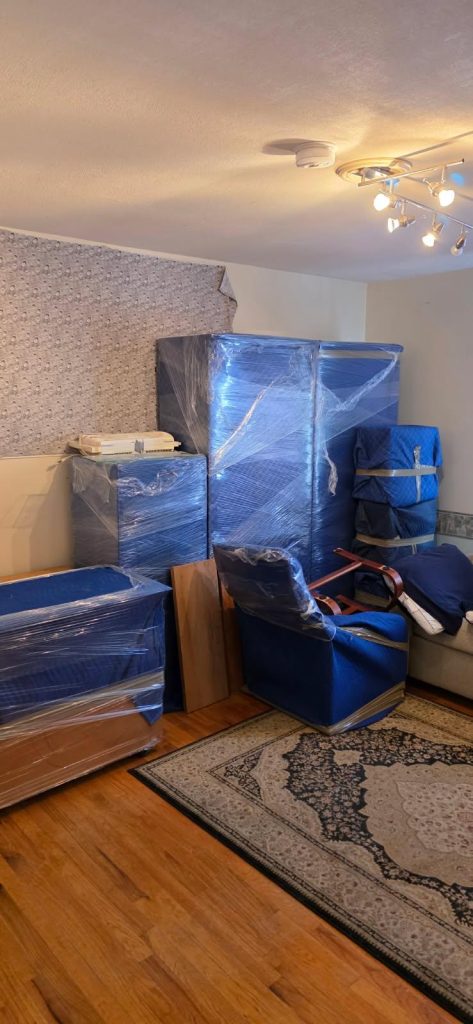 Moving boxes and wrapped furniture staged for interstate move from Skaneateles NY to South Yarmouth MA