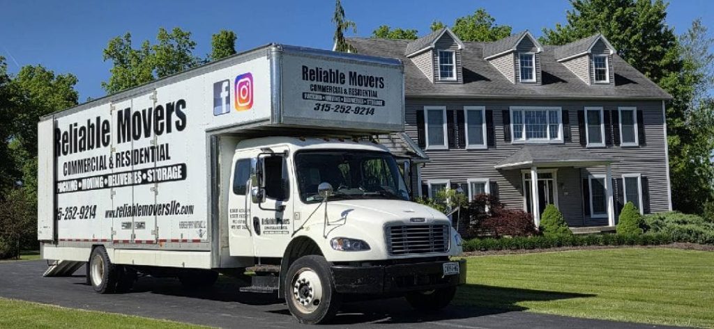 Reliable Movers crew completing a local residential move in Auburn NY with professional movers loading furniture into a company-owned moving truck.