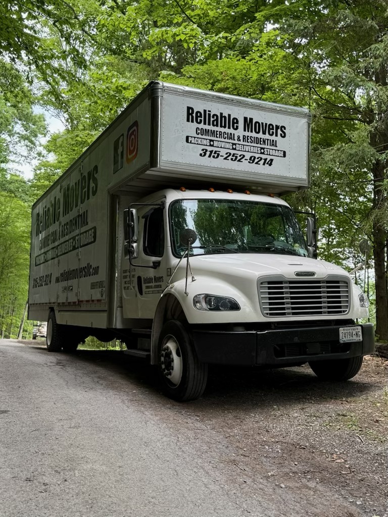 Reliable Movers full-size 30-foot moving truck parked on a wooded road during a residential move from Manlius to Skaneateles.