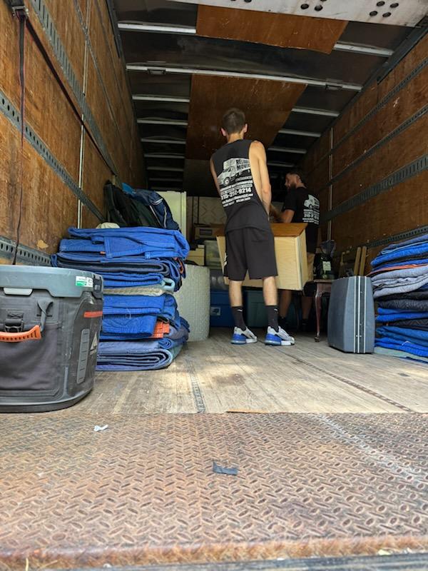 Reliable Movers loading household furniture and moving blankets into a 30-foot moving truck during a large Victorian home relocation in Clinton, NY.