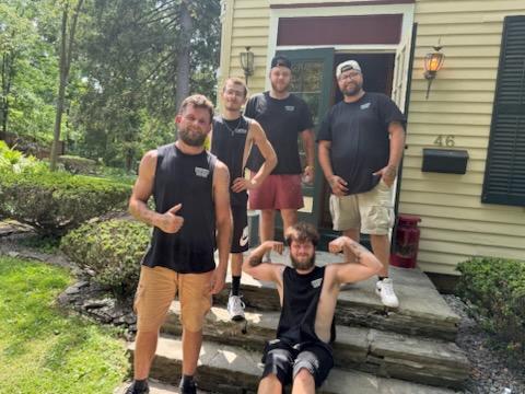 Reliable Movers crew posing outside a large Victorian home after completing a full-service residential move in Clinton, New York on July 1, 2026.