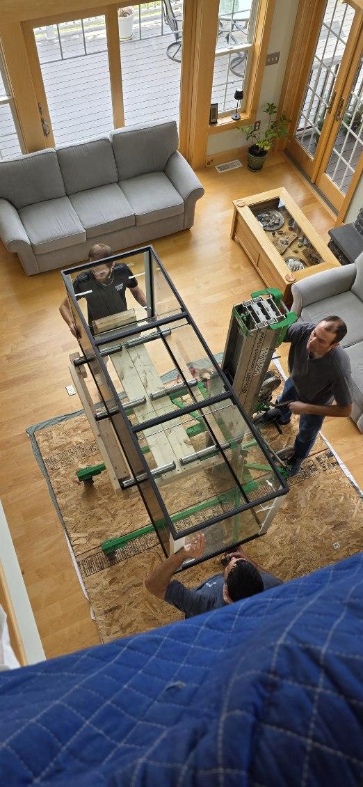 Movers positioning a heavy glass fish tank on a lift in Elbridge NY