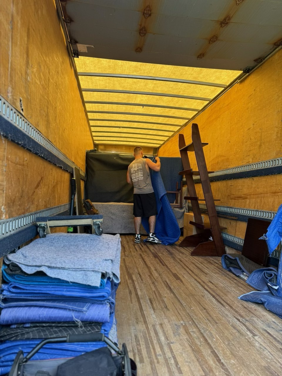 Jonathan loading furniture into a Reliable Movers truck for a Marcellus to Liverpool NY local move