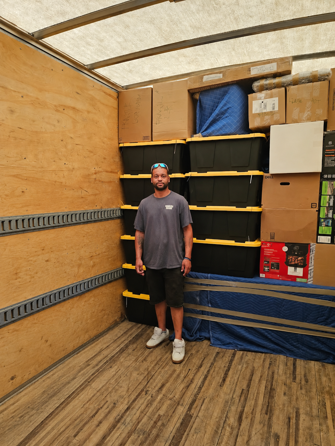 George, Reliable Movers crew member standing inside a loaded moving truck