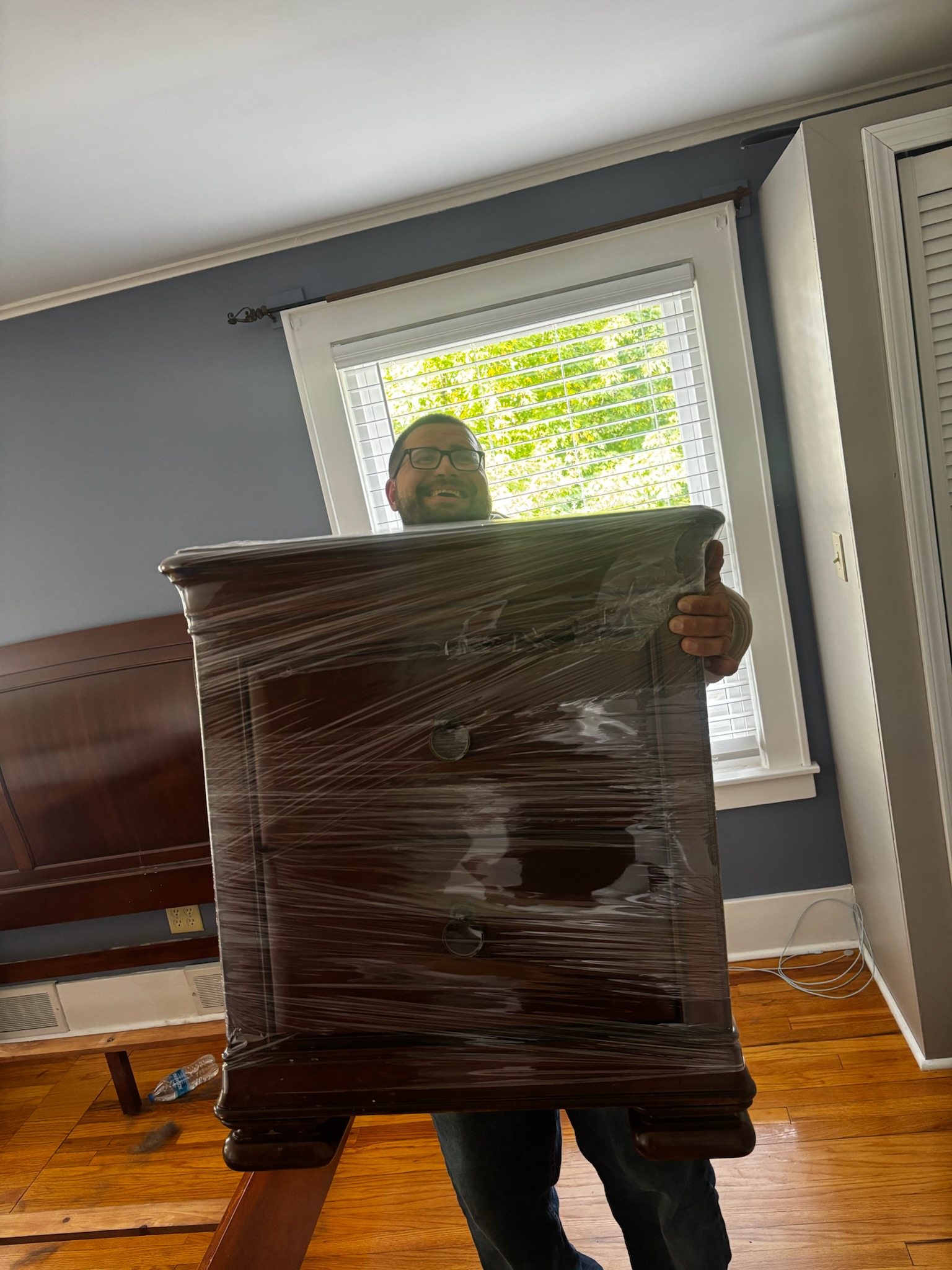 Brandon Meatball of Reliable Movers handling wrapped furniture