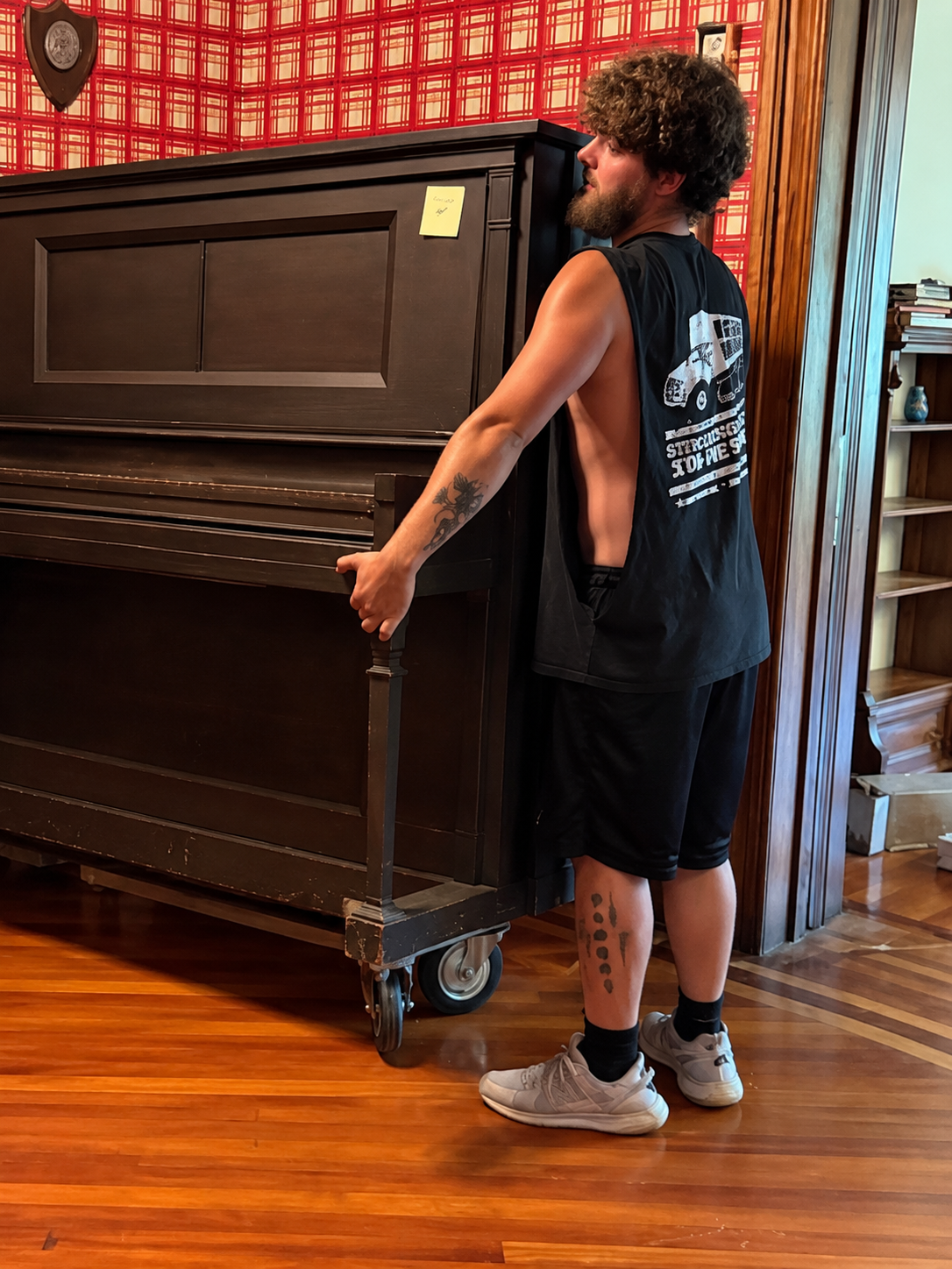 Mehki, Reliable Movers crew member handling an upright piano